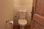 This charming bathroom features a classic toilet design, complemented by a stylish wooden door.