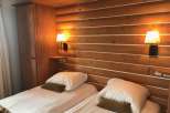 Cozy up in this charming bedroom featuring a rustic wooden headboard and two comfortable beds.