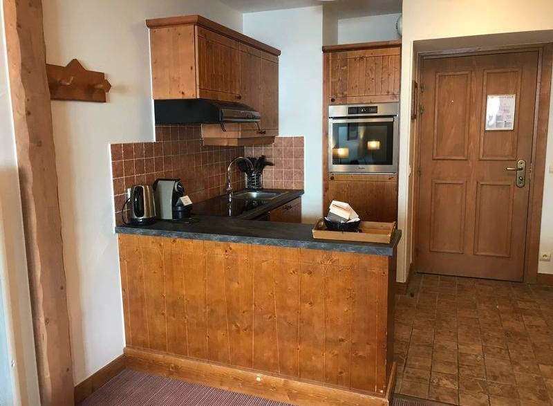 This charming property features a cozy kitchen with wooden cabinetry and a modern oven.