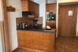 This charming property features a cozy kitchen with wooden cabinetry and a modern oven.