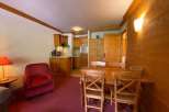 Cozy apartment with a rustic charm, featuring a warm wooden interior and a welcoming dining area.