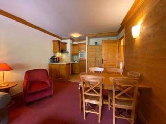 Cozy apartment with a rustic charm, featuring a warm wooden interior and a welcoming dining area.