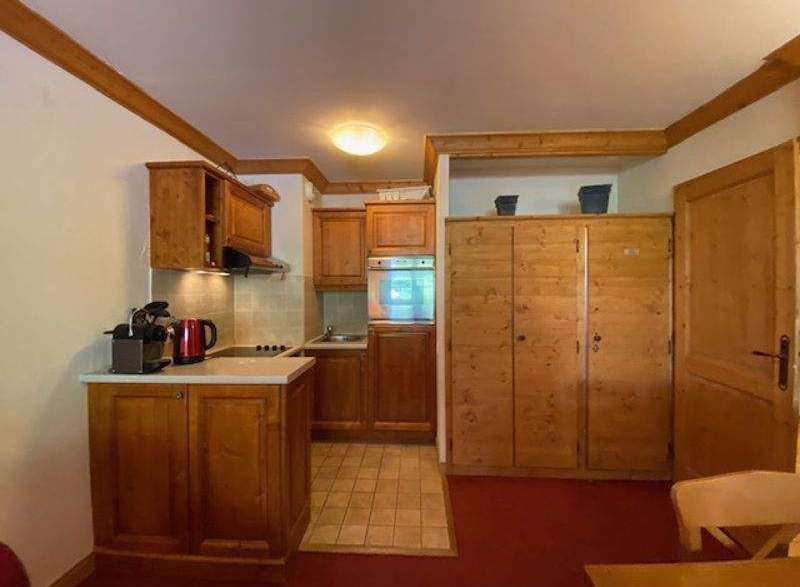Cozy kitchen with wooden cabinets and a tiled floor.