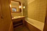 Discover a charming bathroom with a rustic wooden vanity and a sleek, modern sink.