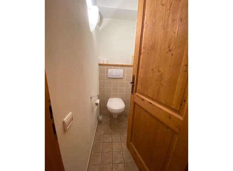 This charming bathroom features a clean white toilet and a convenient toilet paper holder.