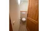 This charming bathroom features a clean white toilet and a convenient toilet paper holder.