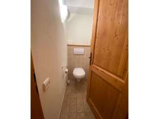 This charming bathroom features a clean white toilet and a convenient toilet paper holder.