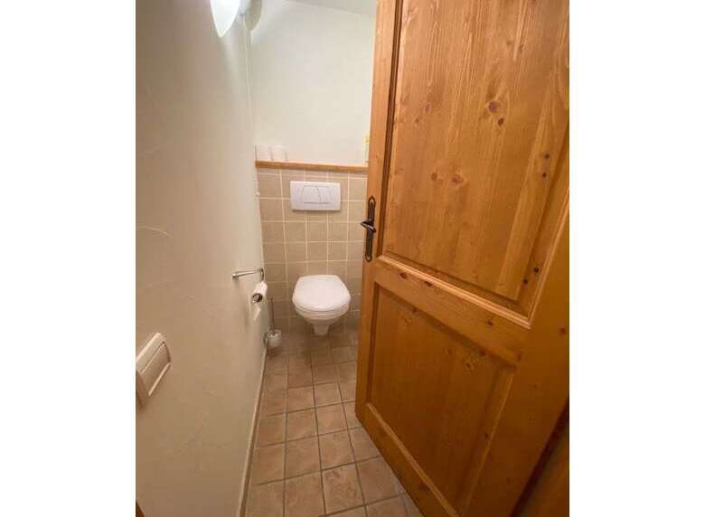 This charming bathroom features a clean white toilet and a convenient toilet paper holder.