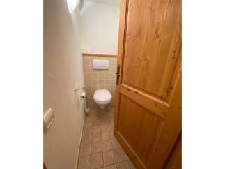 This charming bathroom features a clean white toilet and a convenient toilet paper holder.