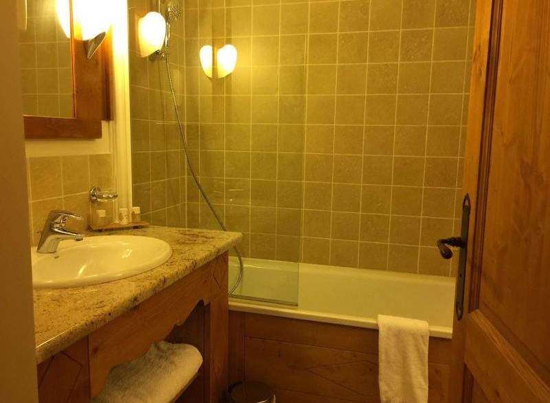This cozy bathroom features a classic design with warm lighting and wooden accents.