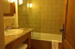 This cozy bathroom features a classic design with warm lighting and wooden accents.