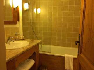 This cozy bathroom features a classic design with warm lighting and wooden accents.