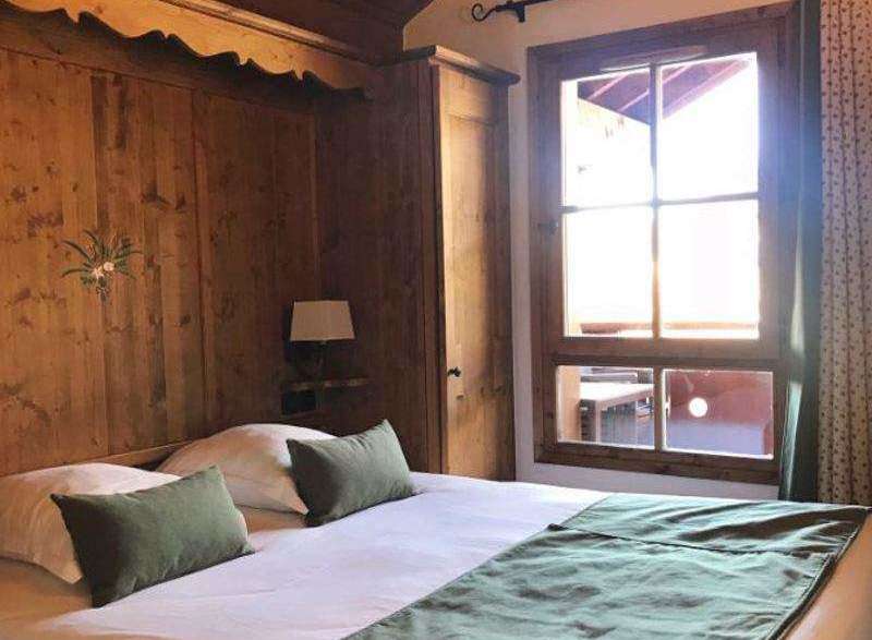 Cozy bedroom with wooden paneling and a comfortable bed.