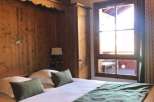 Cozy bedroom with wooden paneling and a comfortable bed.