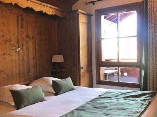 Cozy bedroom with wooden paneling and a comfortable bed.