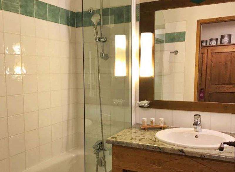This charming bathroom features a sleek glass shower enclosure and a classic white sink.