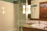 This charming bathroom features a sleek glass shower enclosure and a classic white sink.