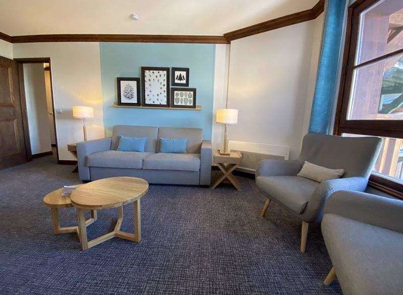 Cozy living room with a comfortable sofa and armchairs, perfect for relaxing.