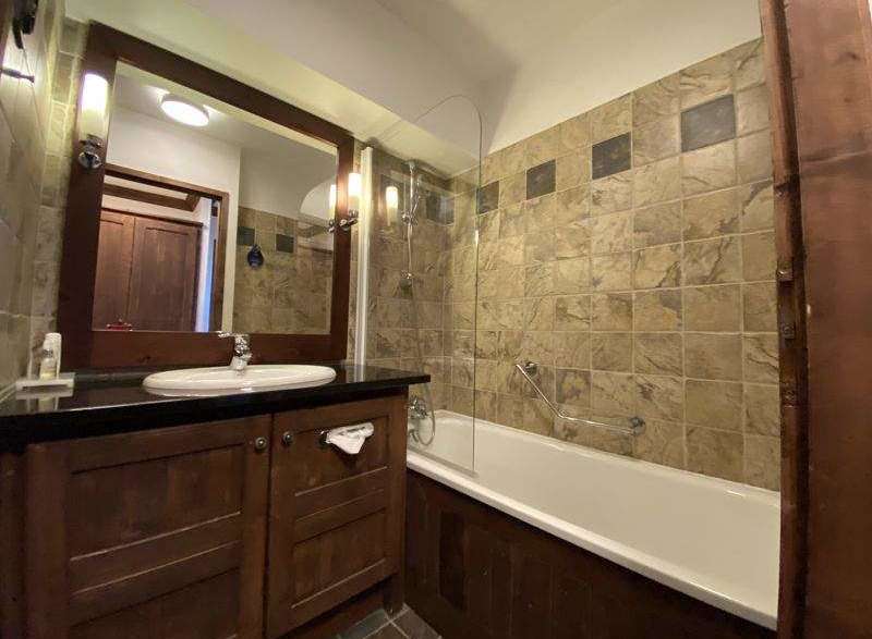 This charming bathroom features a classic design with a wooden vanity and a sleek black countertop.