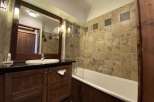 This charming bathroom features a classic design with a wooden vanity and a sleek black countertop.