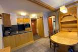 Discover a charming kitchen with wooden cabinets and a cozy dining area.