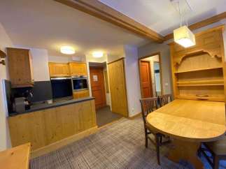 Discover a charming kitchen with wooden cabinets and a cozy dining area.