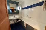 This bathroom features a modern design with a sleek white bathtub and a stylish blue tile floor.