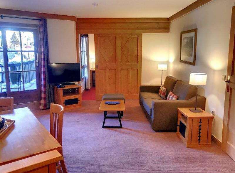 Discover a cozy living space with a comfortable sofa and stylish wooden furniture.