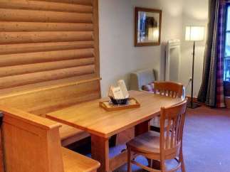 This charming property features a cozy dining area with a wooden table and chairs, perfect for enjoying meals.