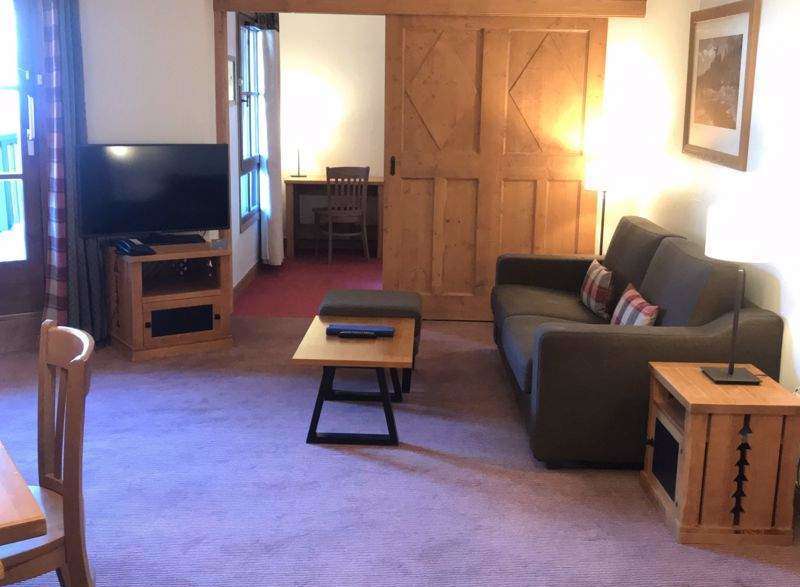 This cozy living space features a comfortable sofa and a stylish wooden coffee table, perfect for relaxing.