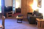 This cozy living space features a comfortable sofa and a stylish wooden coffee table, perfect for relaxing.