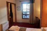 Cozy hotel room featuring a comfortable bed with a plush robe, perfect for relaxation.