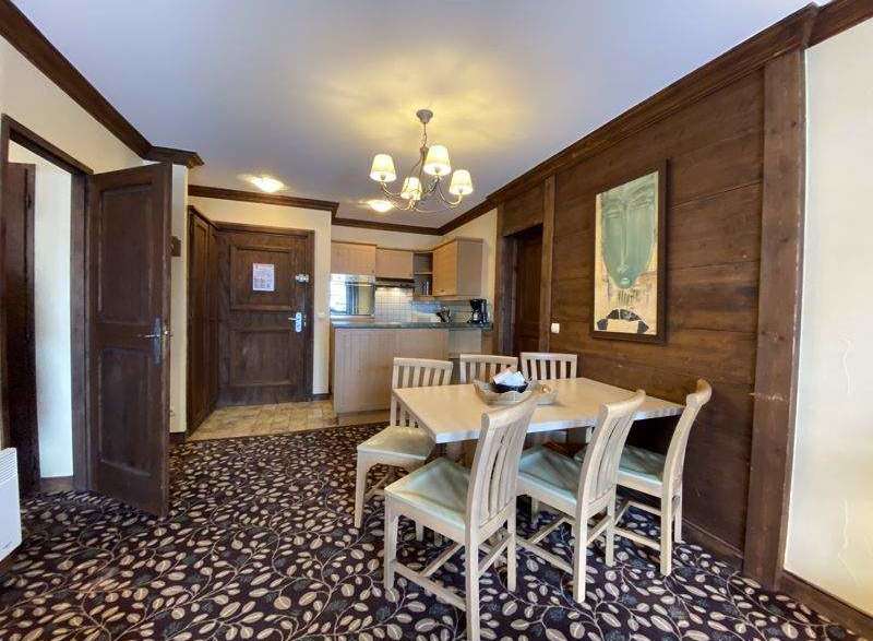 Discover a charming dining area with a rustic wooden wall and a stylish chandelier.
