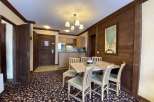 Discover a charming dining area with a rustic wooden wall and a stylish chandelier.