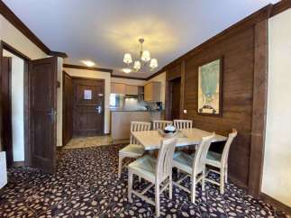 Discover a charming dining area with a rustic wooden wall and a stylish chandelier.