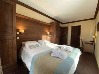 Cozy bedroom with wooden accents and a comfortable bed.