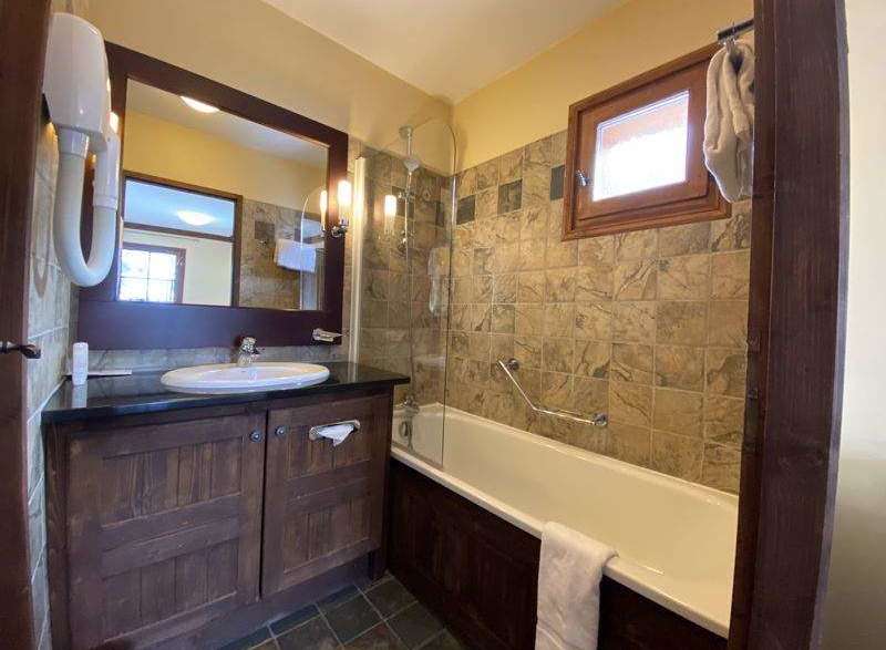 This charming bathroom features a rustic wooden vanity and a sleek, modern sink.