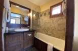 This charming bathroom features a rustic wooden vanity and a sleek, modern sink.