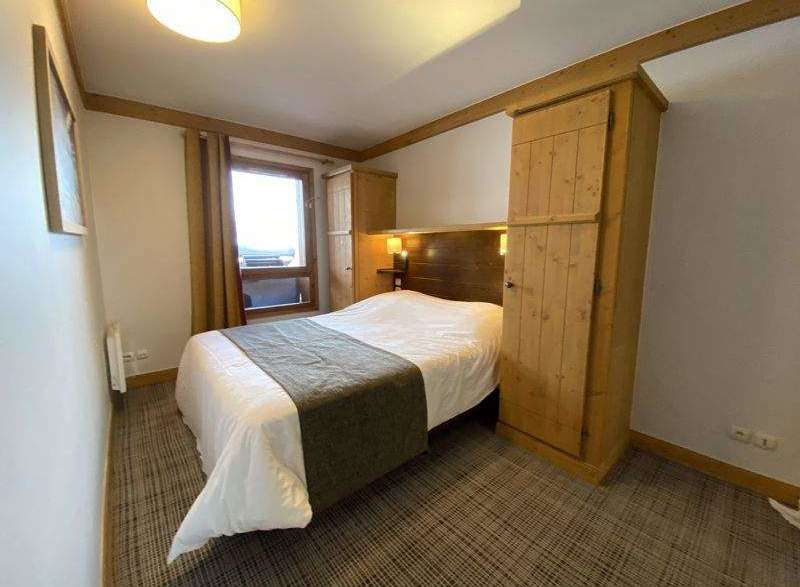 Cozy bedroom with a comfortable bed and a stylish wooden wardrobe.