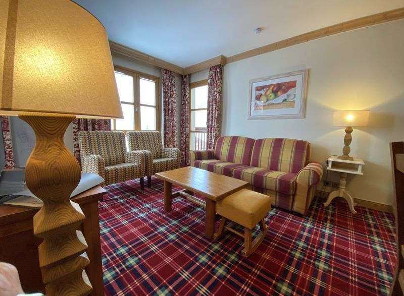 Cozy living room with a plaid carpet and a comfortable sofa.