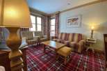 Cozy living room with a plaid carpet and a comfortable sofa.
