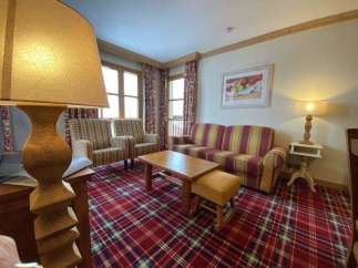 Cozy living room with a plaid carpet and a comfortable sofa.