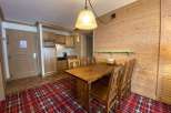 This cozy space features a charming wooden dining table and chairs, perfect for enjoying meals.