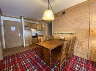 This cozy space features a charming wooden dining table and chairs, perfect for enjoying meals.
