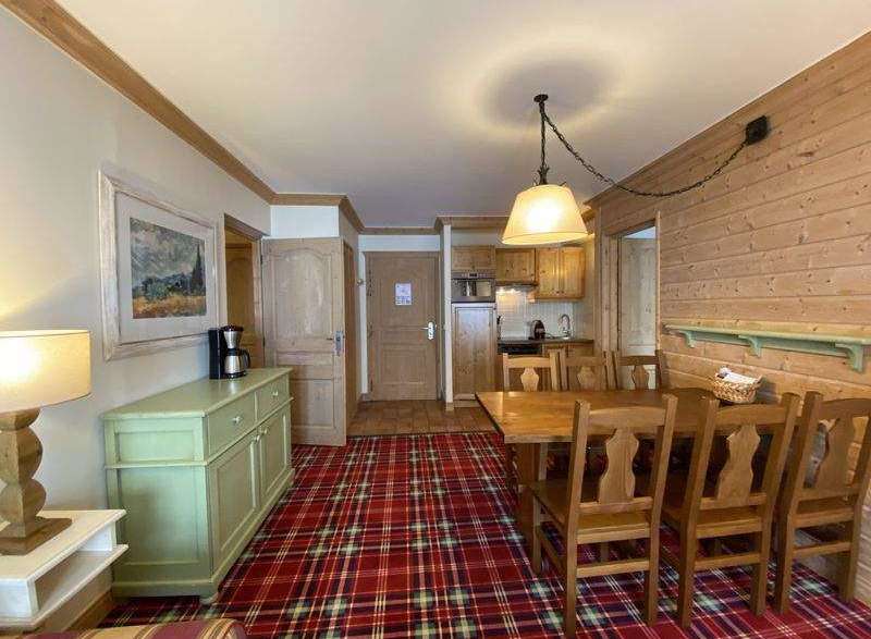 This charming property features a cozy living space with a rustic wooden dining set, perfect for enjoying meals.
