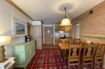 This charming property features a cozy living space with a rustic wooden dining set, perfect for enjoying meals.
