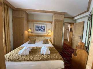Cozy bedroom with wooden accents and a comfortable bed.