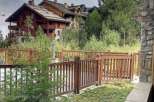 Discover a charming property nestled in a picturesque setting, featuring a beautifully crafted wooden fence that enhances its curb appeal.