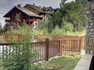 Discover a charming property nestled in a picturesque setting, featuring a beautifully crafted wooden fence that enhances its curb appeal.