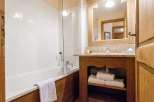 This charming bathroom features a classic design with wooden accents and a bright, inviting atmosphere.